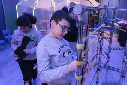 un enfant en situation de handicap essaie un instrument de musique adapté