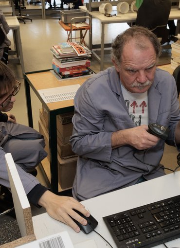 Atelier Recyclivre, deux employés trient les livres