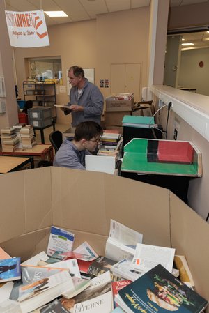 Atelier Recyclivre, deux employés trient les livres